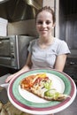 Friendly smiling waitress serving a slice of pizza Royalty Free Stock Photo