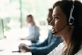 Friendly smiling woman call center operator with headset using computer at office. Royalty Free Stock Photo