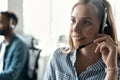 Friendly smiling woman call center operator with headset using computer at office. Royalty Free Stock Photo