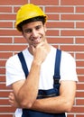 Friendly smiling worker in front of a brick wall