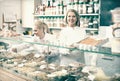 Friendly staff offering sweets in confectionery Royalty Free Stock Photo