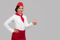 Friendly stewardess gesturing thumb up