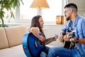 Friendly teacher and little pupil child girl singing and playing guitar in cozy room Royalty Free Stock Photo