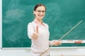 Friendly teacher standing in front of blackboard in class