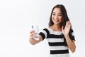 Friendly, tender young asian woman in casual outfit talking via internet video-call, holding smartphone taking selfie Royalty Free Stock Photo