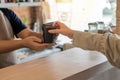 Friendly waiter staff or barista serving hot black coffee cup to female customer in cafe coffee shop Royalty Free Stock Photo