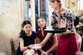 Friendly waitress serving coffee in a stylish restaurant Royalty Free Stock Photo