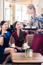 Friendly waitress serving coffee in a stylish restaurant Royalty Free Stock Photo