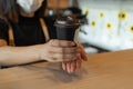 Friendly woman barista wearing protection face mask waiting for serving ice black coffee to customer in cafe coffee shop Royalty Free Stock Photo