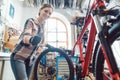 Woman bike mechanic in her workshop changing a tire