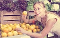 Friendly woman holding lemons in hands in fruit store Royalty Free Stock Photo