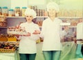 Friendly women staff offering sweets Royalty Free Stock Photo