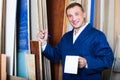 friendly workman standing with plywood pieces