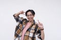 A friendly young asian man making two peace signs while smiling. Isolated on a white background