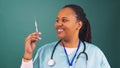 Friendly young Black doctor holds up injection needle syringe, squirts medicine Royalty Free Stock Photo