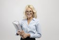 Friendly young businesswoman holding folder with business reports in hands, smiling at camera over light background Royalty Free Stock Photo