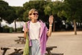 Friendly young caucasian woman waving meeting friends in nature going on picnic.