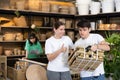 Friendly young couple looking at folded wooden chair in store Royalty Free Stock Photo