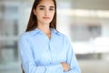 A friendly young dark hair businesswoman or female student is standing with some papers in the office