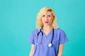 Friendly young female doctor or nurse wearing blue scrubs and stethoscope Royalty Free Stock Photo