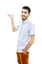 Friendly young man pointing to his side and looking into the camera Royalty Free Stock Photo