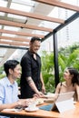 Friendly young waiter talking with the clients outdoors Royalty Free Stock Photo