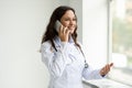 Friendly young woman doctor have remote consultation, talking on phone Royalty Free Stock Photo