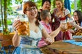 Friends in Bavarian beer garden or oktoberfest drinking in summer Royalty Free Stock Photo