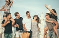 Group of Friends Walking at Beach, having fun, womans piggyback on mans, funny vacation Royalty Free Stock Photo