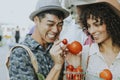 Friends buying fresh tomatoes at a farmers market Royalty Free Stock Photo