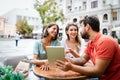 Friends at cafe talking laughing and enjoying their time using digital tablet. Royalty Free Stock Photo