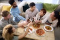 Friends Celebrating With Cheers At Home In Kitchen Eating Homemade Pizzas
