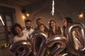 Friends celebrating New Year, holding sparklers and giant 2020 balloons Royalty Free Stock Photo