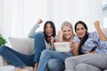 Friends cheering at television with bowl of popcorn Royalty Free Stock Photo