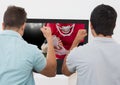 Friends cheering while watching american football match on television Royalty Free Stock Photo