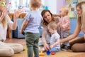 Friends with children playing on the floor in sitting room Royalty Free Stock Photo