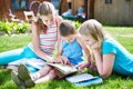 Friends children reading book outdoori on grass Royalty Free Stock Photo