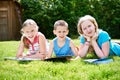 Friends children reading book outdoori on grass Royalty Free Stock Photo