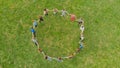 Friends in a circle holding hands make a round dance in the field. Royalty Free Stock Photo