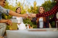 Friends clink glasses at table, picnic at camping