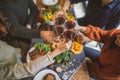 Friends clinking glasses above food on dinner table