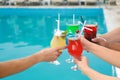 Friends clinking glasses with fresh summer  near swimming pool, closeup Royalty Free Stock Photo