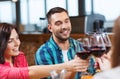 Friends clinking glasses of wine at restaurant