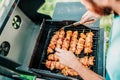 Friends cooking on grill during summertime. Portrait of man grilling and having a garden barbecue party Royalty Free Stock Photo