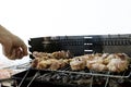 Friends cooking tasty food on barbecue grill outdoors. Grilling at summer weekend. Fresh meat in kebab. Hand man making chicken in Royalty Free Stock Photo