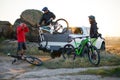 Friends Taking MTB Bikes off the Pickup Offroad Truck in Mountains at Sunset. Adventure and Travel Concept.