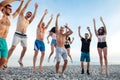 Friends dance on beach under sunset sunlight, having fun, happy, enjoy Royalty Free Stock Photo