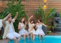 Friends dance at a party in the swimming pool. Fun in the outdoor summer club Royalty Free Stock Photo