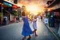 Friends dance on the street in dresses