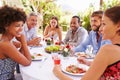 Friends dining together at a table in a garden